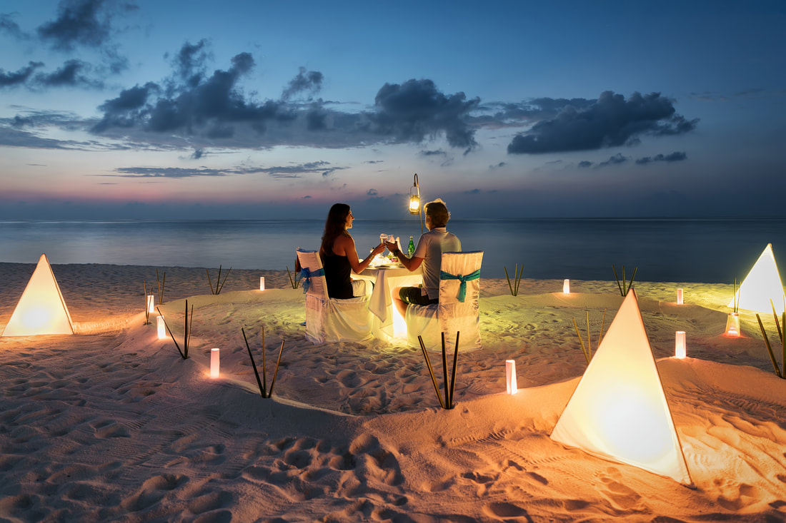 couple having candle lit dinner on beach